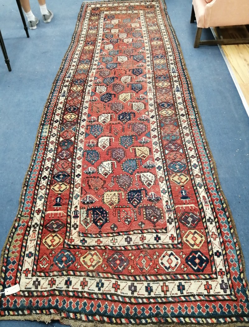A Gendje red ground runner, c.1900, with polychrome field of stylised pears and multi row border, 410 x 118cm
